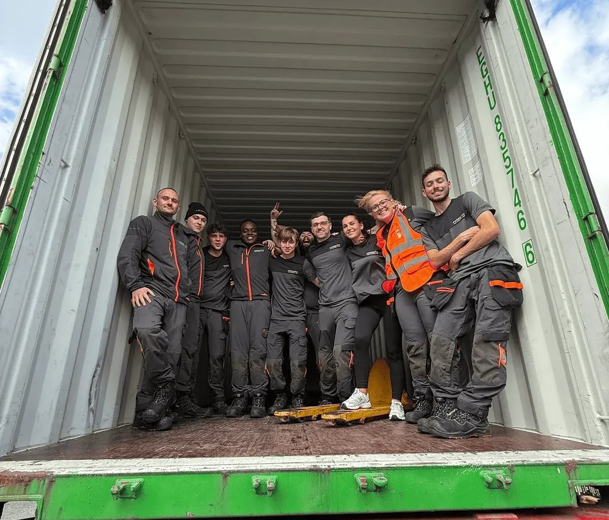 The team standing inside an open shipping container at Unit 19